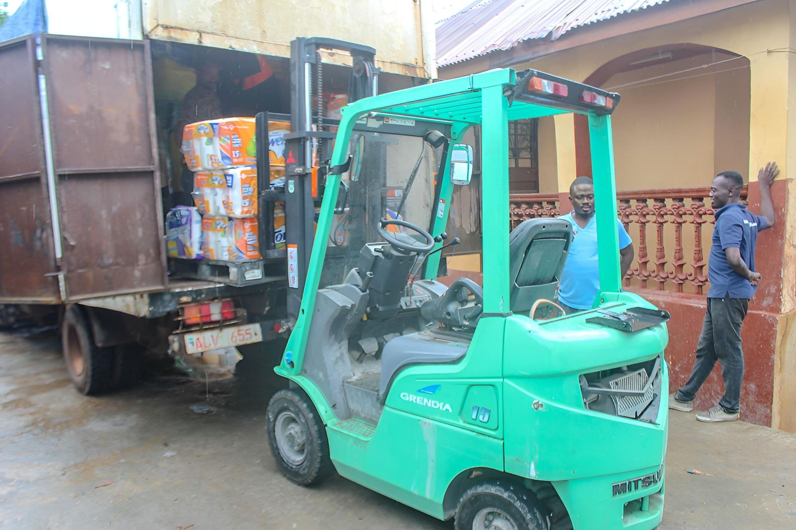 Forklift lifting a pallet of household goods off the truck